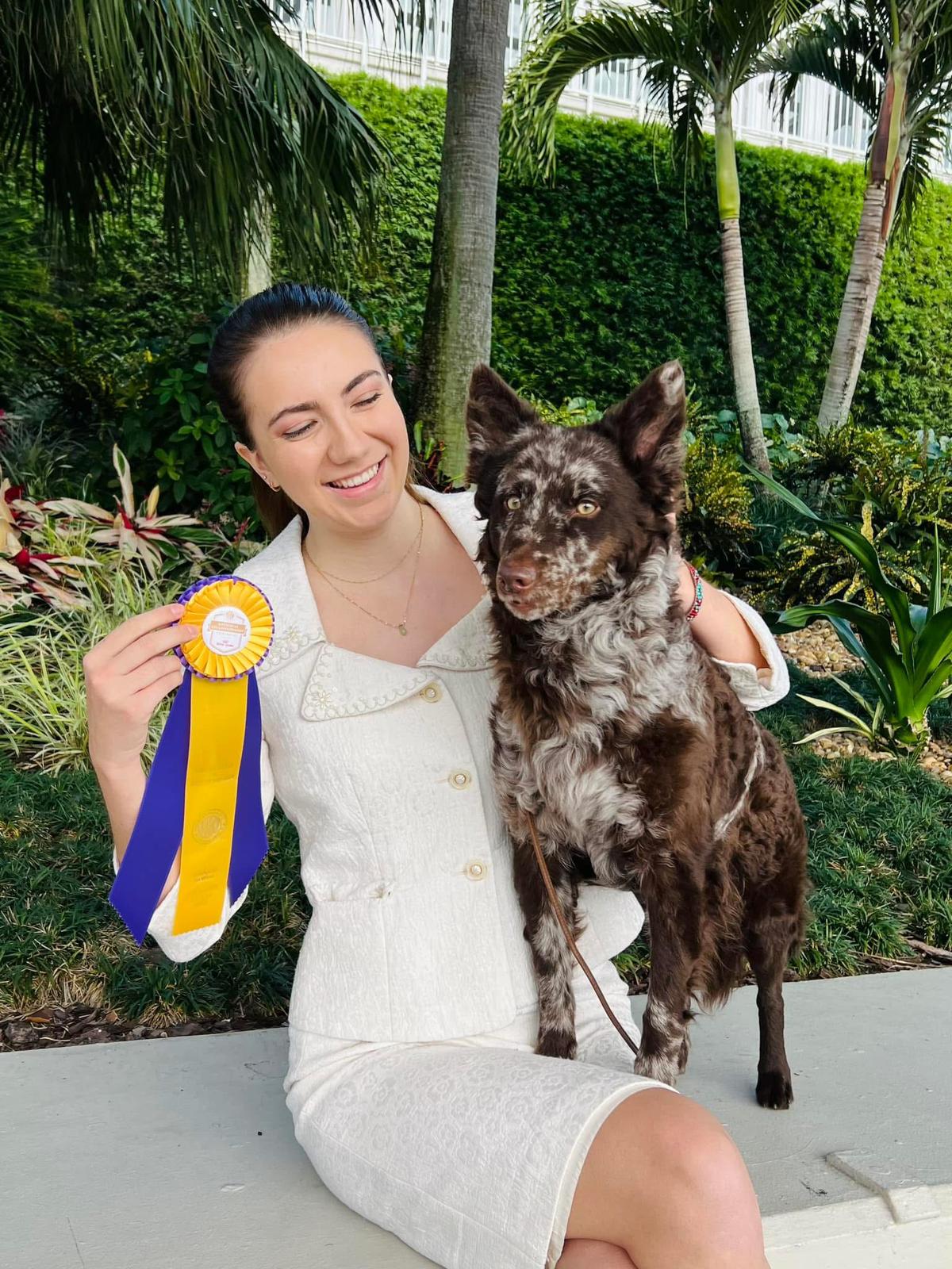 Sam Van Buren, founder of DogStack, with her Mudi and a dog-show ribbon